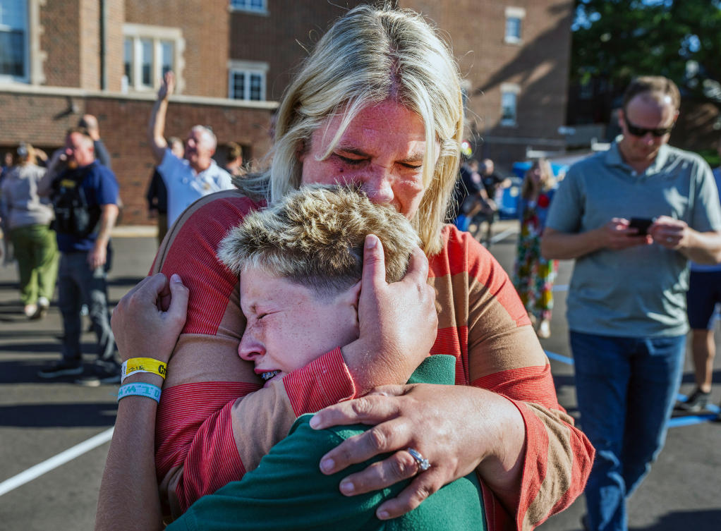 A parent hugs her son during a shooting at the Annunciation Church in Minneapolis on Wednesday. (AP)