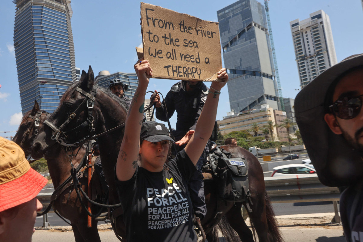 An Israeli protester raises a placard during an anti-government rally in Tel Aviv on August 17, 2025. (AFP)