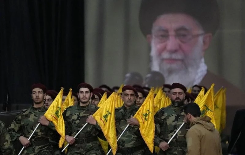Hezbollah fighters parade in front of an image of Ali Khamenei in southern Beirut, Lebanon, in 2023. (AP Photo)