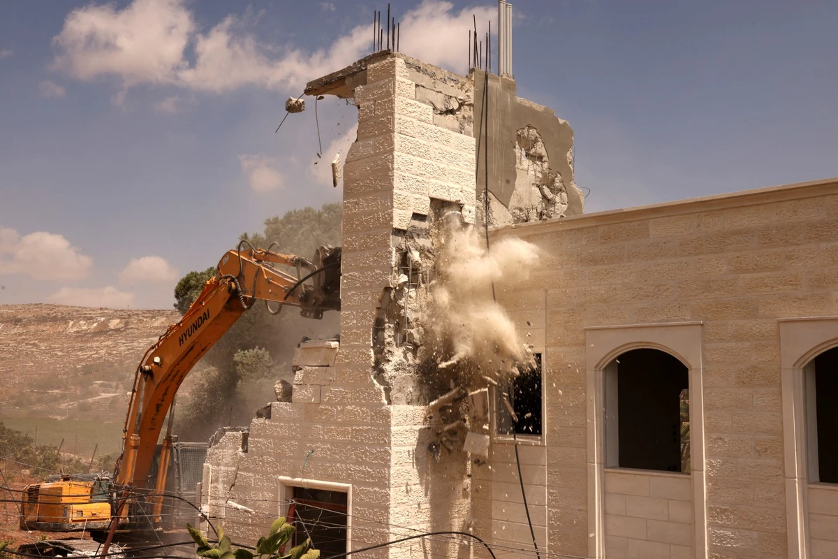 Bulldozers demolish a Palestinian house built without a permit from the Israeli authorities in Area C, which lies under Israel's military control since 1967, in Hebron in the occupied West Bank, August 29, 2023. (AFP)