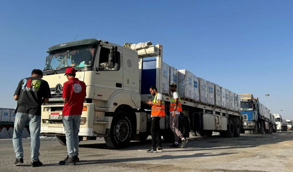 Trucks loaded with humanitarian aid, on the Egyptian side of the Rafah border crossing, await permission to cross into Gaza, Aug. 3, 2025. (AFP)