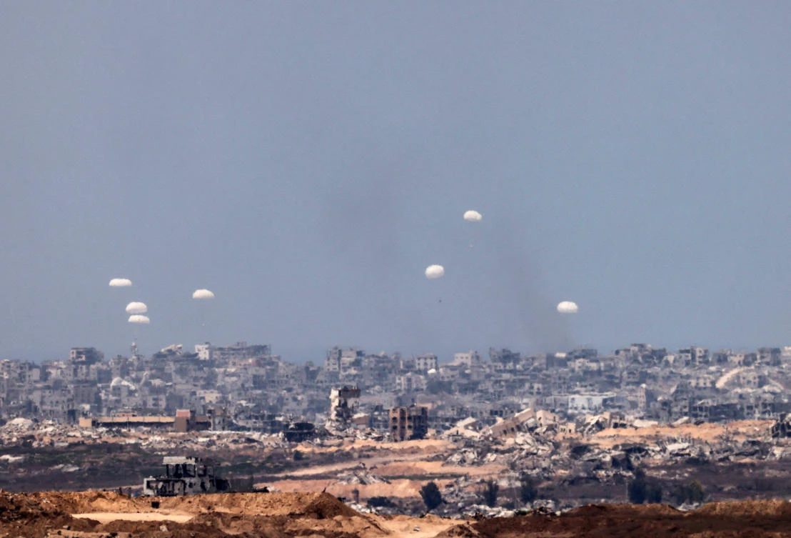 Humanitarian aid packages are airdropped over the Gaza Strip, as seen from Israel on Saturday. (Reuters)