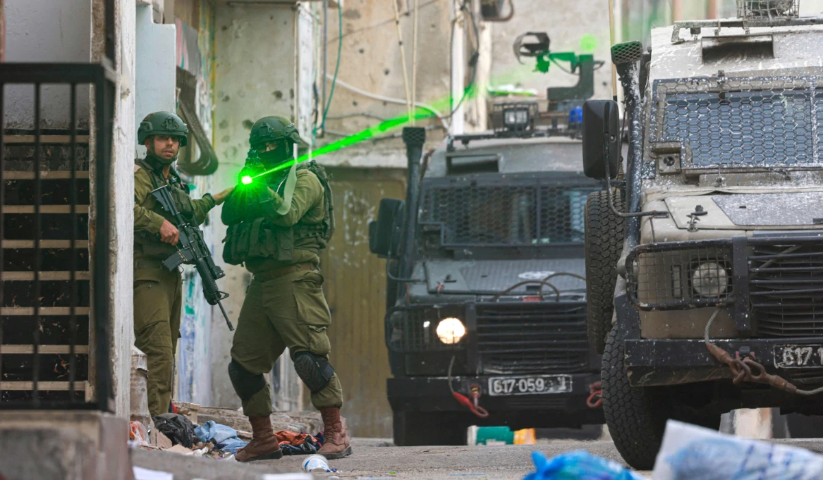 An Israeli soldier aims his weapon during a raid at the Balata refugee camp east of Nablus city in the occupied West Bank on August 11, 2025. (AFP)