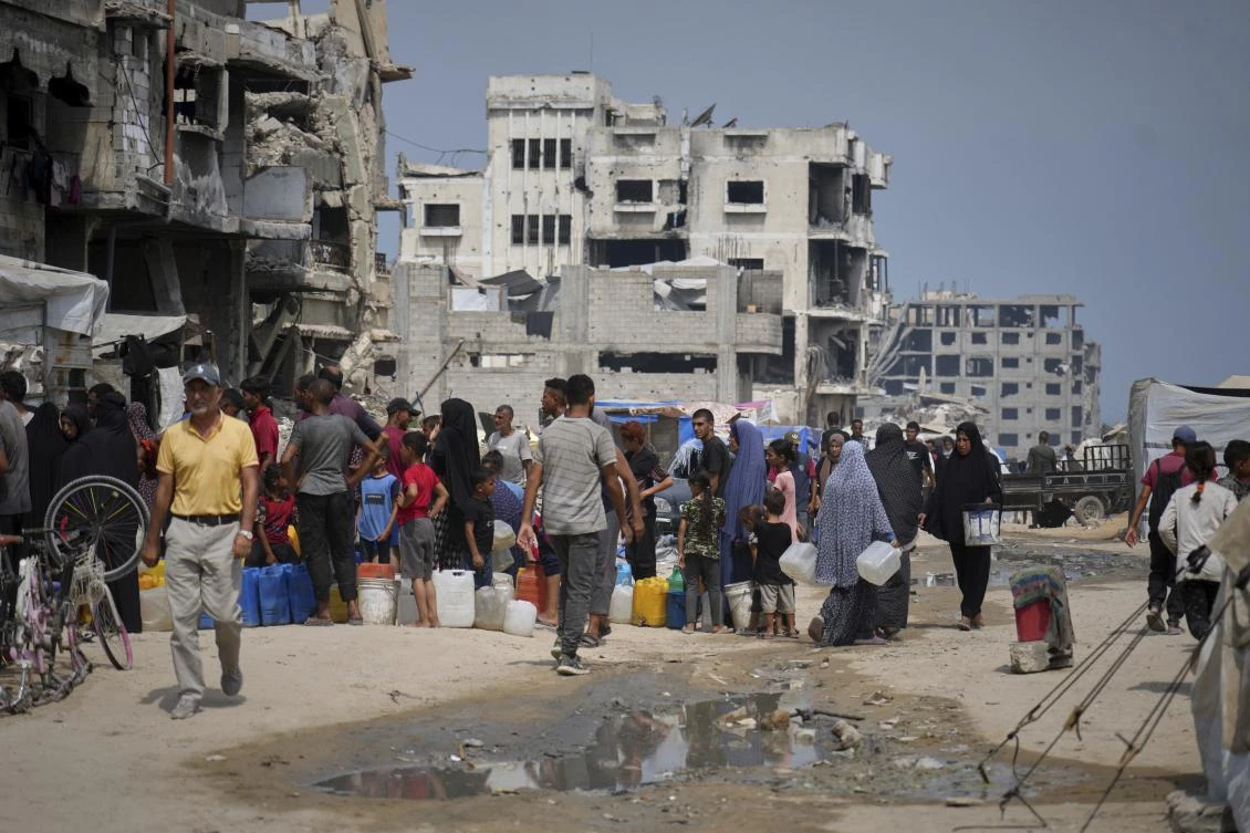 In the summer heat, Palestinians line up to collect water from a distribution point in Gaza City, Tuesday, Aug. 12, 2025. (AP)