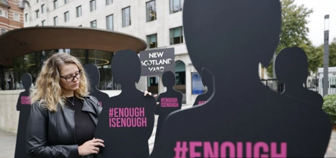 A campaigner poses with cut-out silhouettes representing women outside the Metropolitan Police headquarters New Scotland Yard in London, UK. (AFP)