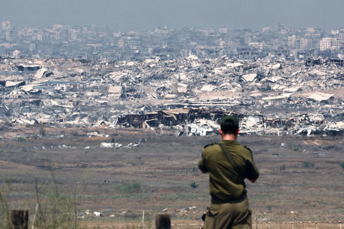 An Israeli army soldier looks at destroyed buildings in the Gaza Strip as troops stand on the border with the Palestinian territory, Aug. 13, 2025. (AFP)
