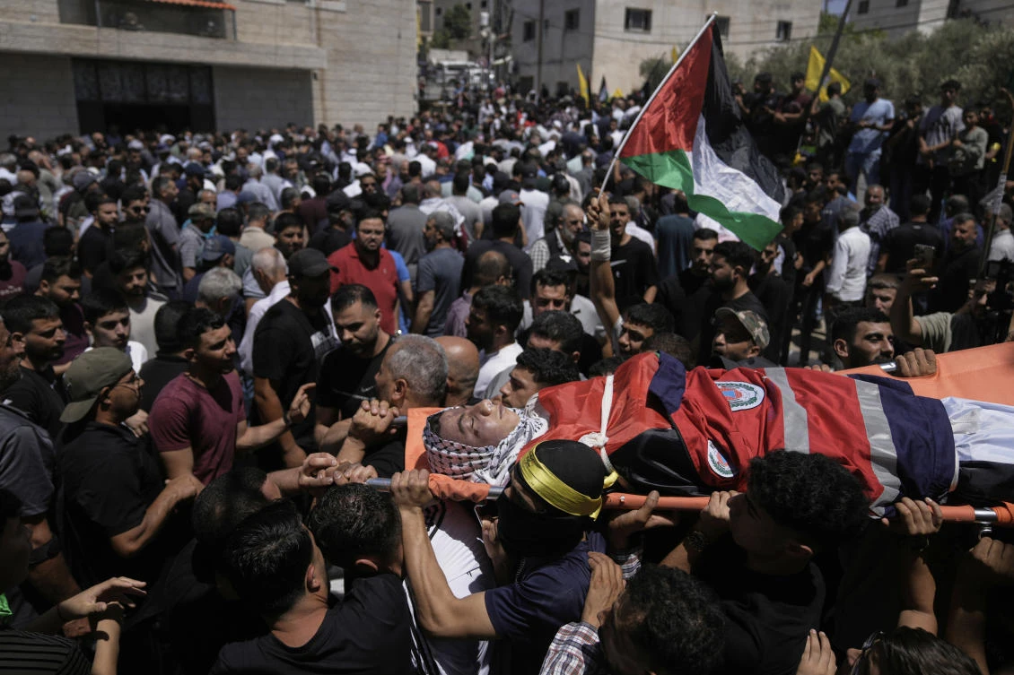Mourners carry the body of Hamdan Abu Aliya, 18, who was killed by Israeli forces following a settler’s attack, during his funeral in the West Bank village of Al-Mughayyir, Sunday, Aug. 17, 2025. (AP)