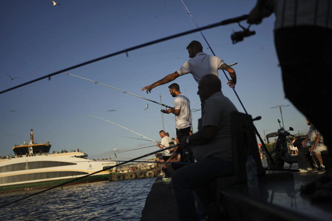 Fishermen cast their lines into the Bosphorus at Eminonu ferry terminal, in Istanbul, Turkey, Saturday, Aug. 16, 2025. (AP)