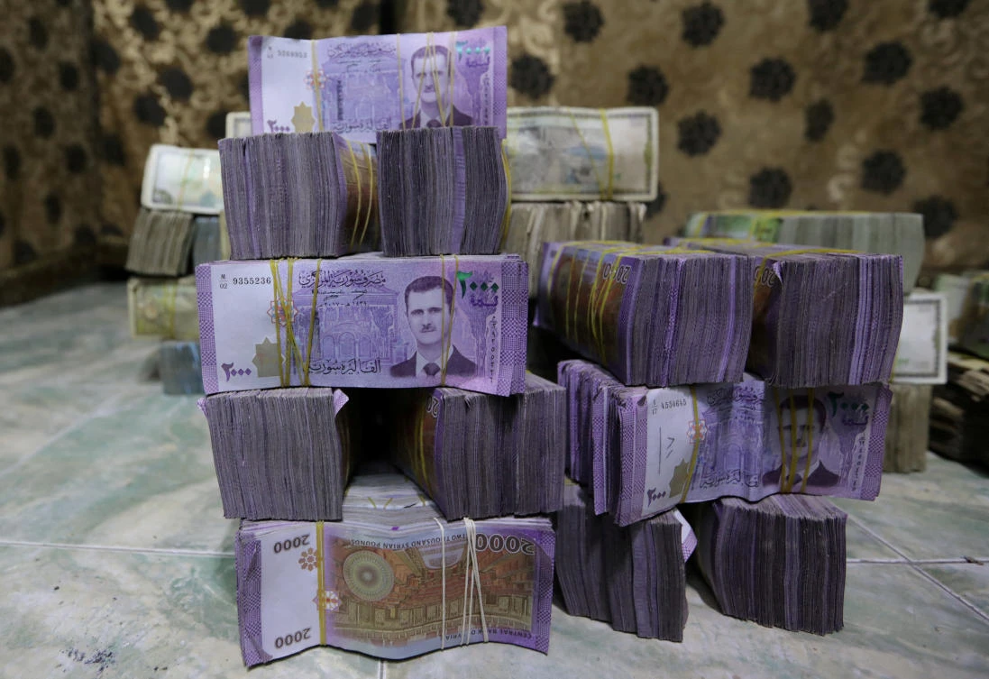 Stacks of Syrian pounds are pictured inside an exchange currency shop in Azaz, Syria February 3, 2020. Picture taken February 3, 2020. (REUTERS)