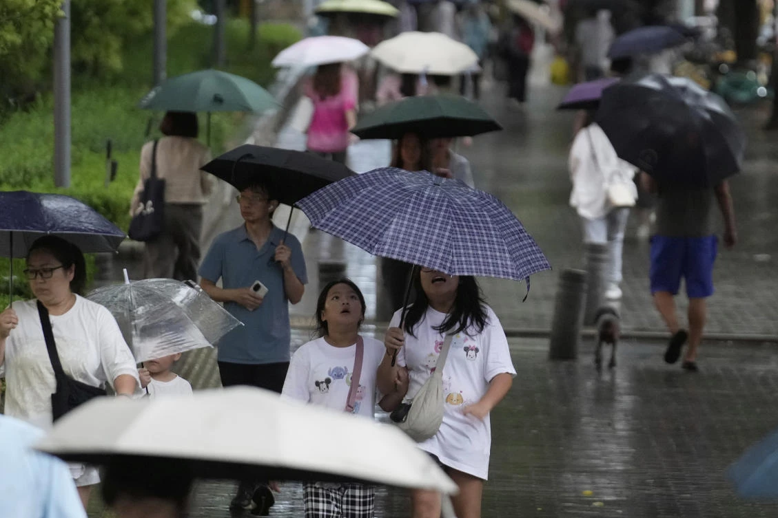 People walk with umbrellas during the rain in Beijing, China, Tuesday, Aug. 19, 2025. (AP)