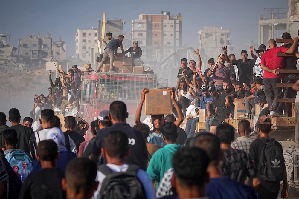 Palestinians ride on a truck loaded with food and humanitarian aid from the World Food Program, after it arrived in the northern Gaza Strip, June 16, 2025. (AP/File Photo)