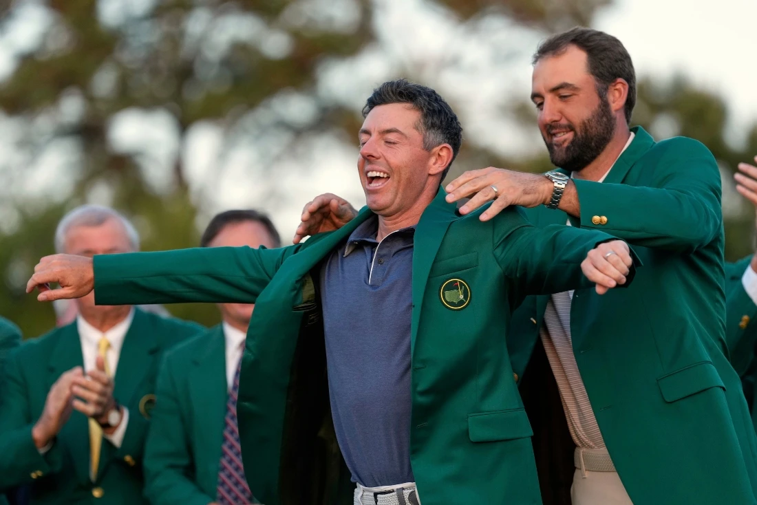 Scottie Scheffler puts the green Jacket on winner, Rory McIlroy, of Northern Ireland, at the Masters golf tournament on April 13, 2025, in Augusta, Ga. (File/AP)