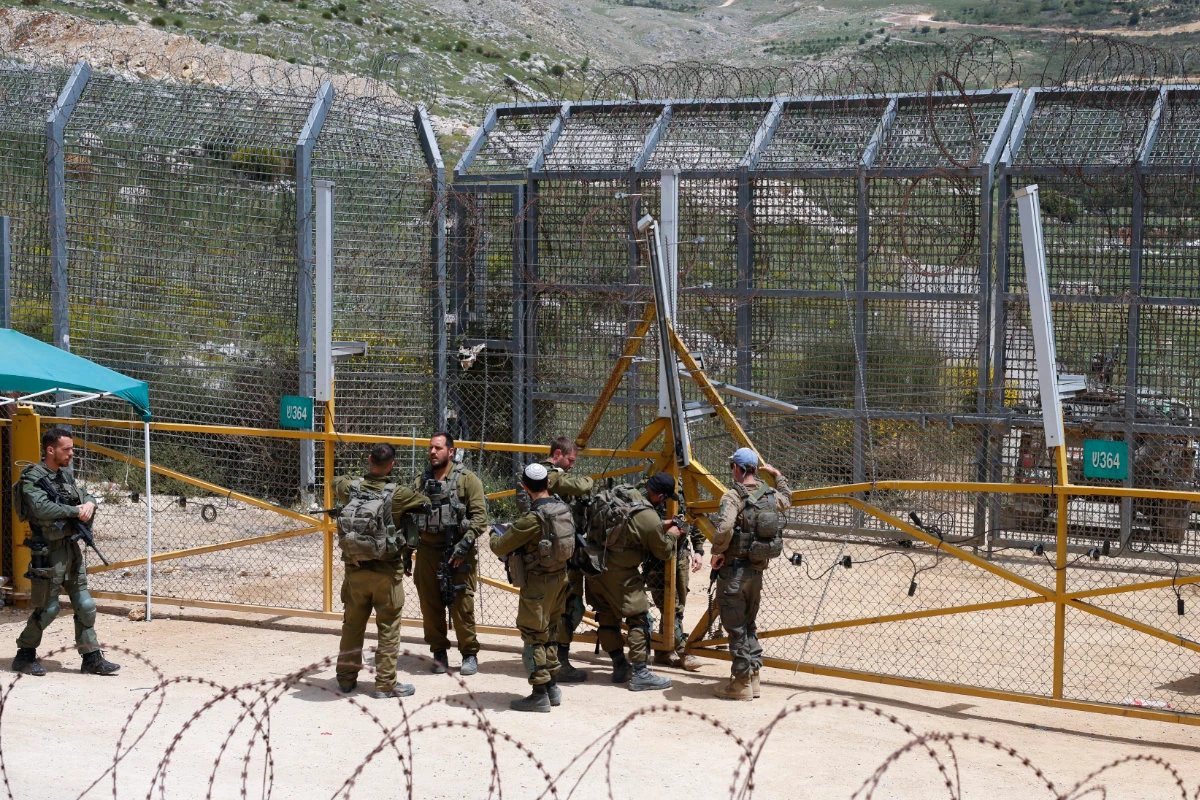 Israeli soldiers stand guard near the border barrier in the village of Majdal Shams in the Israeli-annexed Golan Heights on April 30, 2025. (AFP/File)