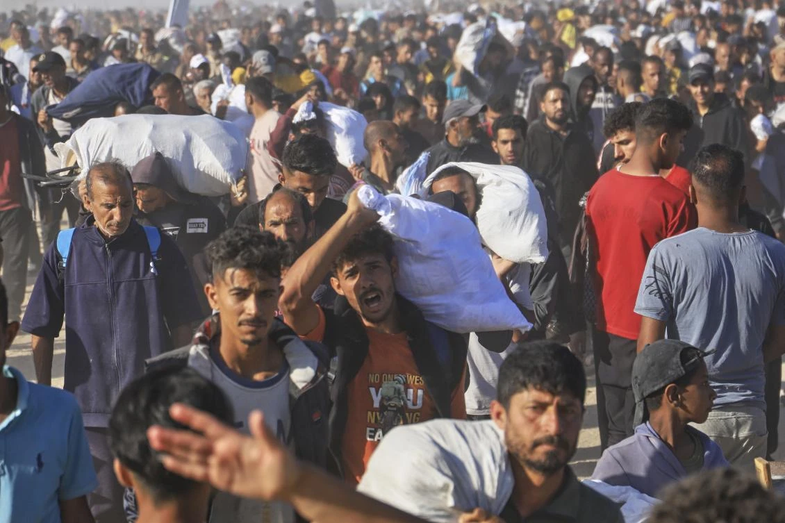Palestinians carry boxes and bags containing food and humanitarian aid packages delivered by the Gaza Humanitarian Foundation (GHF) in Rafah, southern Gaza Strip, May 29, 2025. (AP Photo)