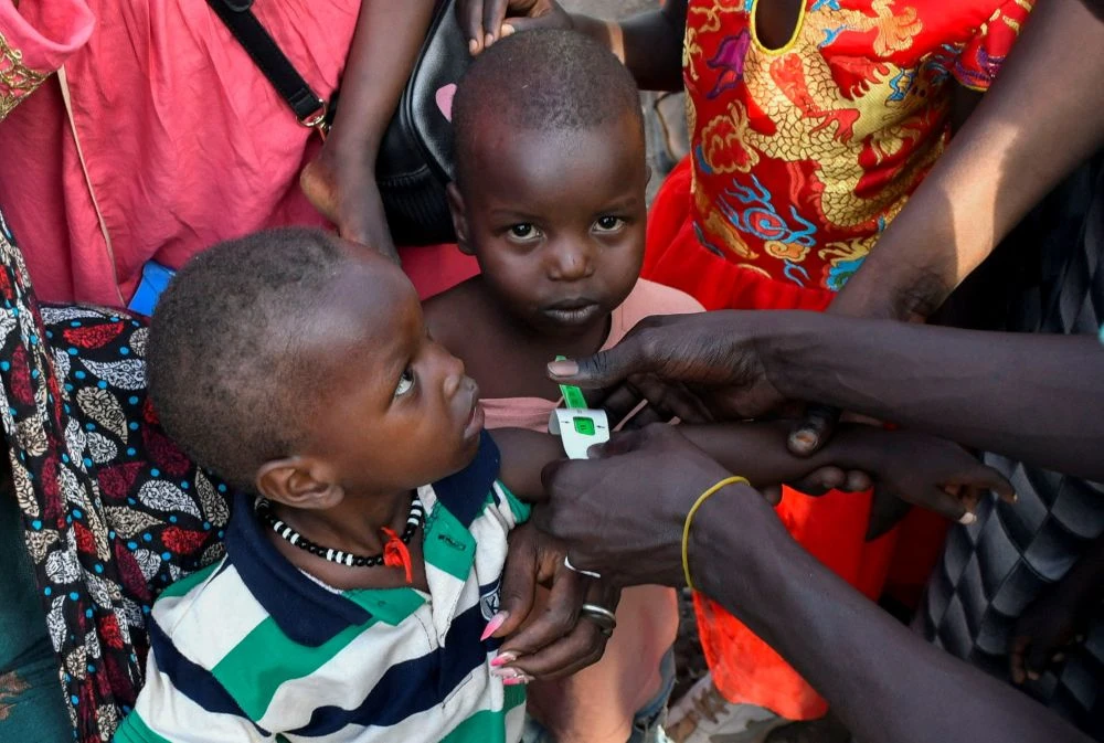 Children are examined for malnutrition by the UNHCR after crossing, from Sudan, through the Joda border point, Renk County, Upper Nile state, South Sudan, Apr. 30, 2023. (Reuters)