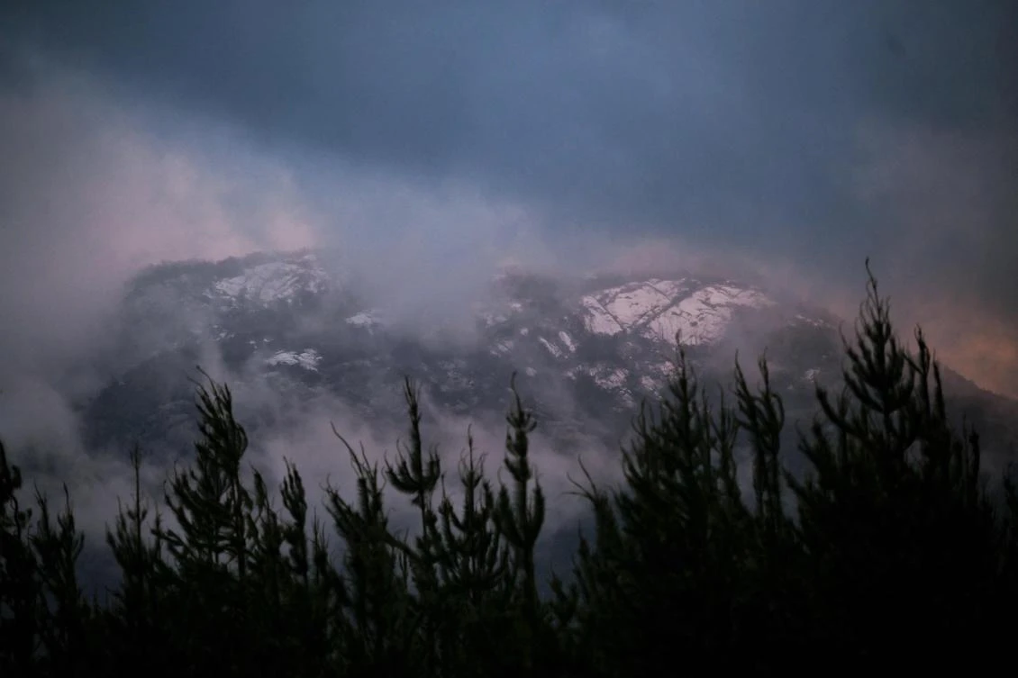 Snow settles on the hills in the area where police are searching for a fugitive linked to the murder of two Australian police officers in Porepunkah on Aug. 29, 2025. (AFP)