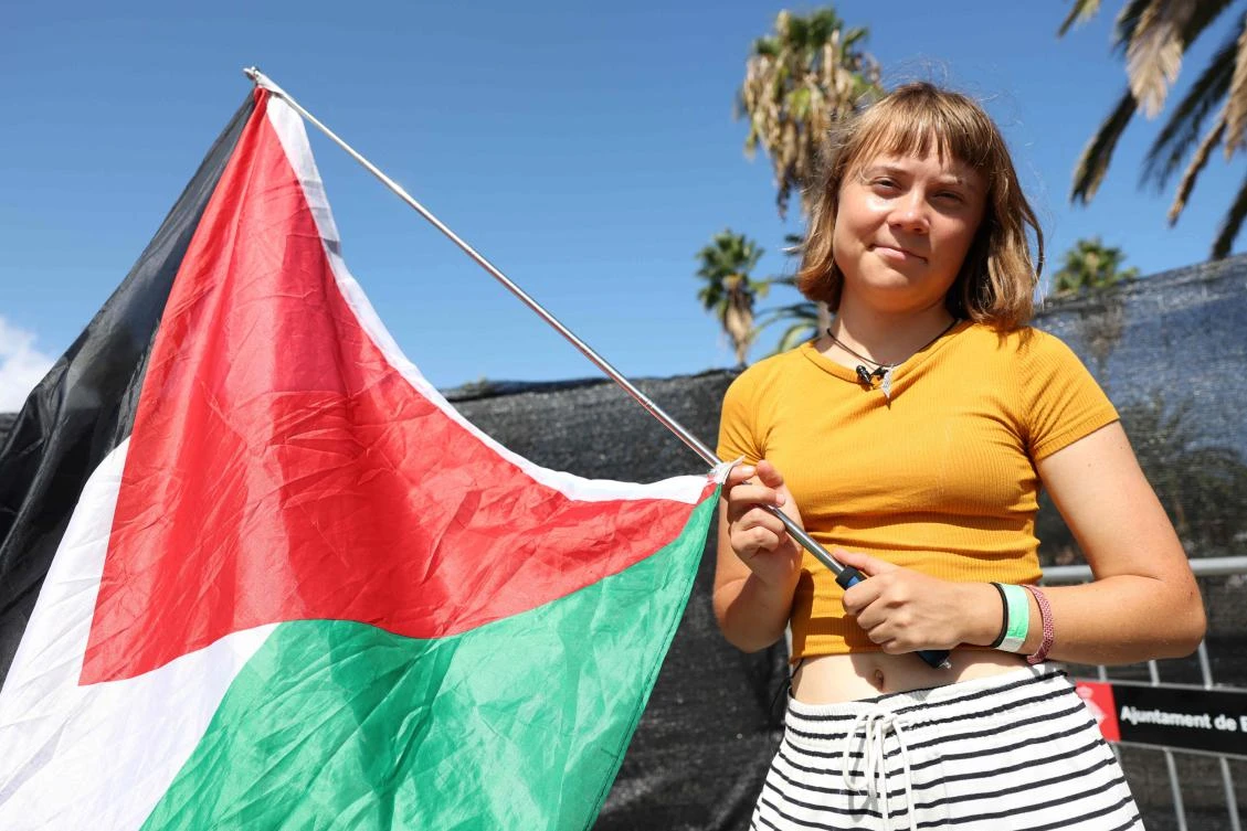Swedish climate activist Greta Thunberg poses with a Palestinian flag as a flotilla carrying humanitarian aid and activists prepare to leave for Gaza, in Barcelona on Aug. 30, 2025. (AFP)