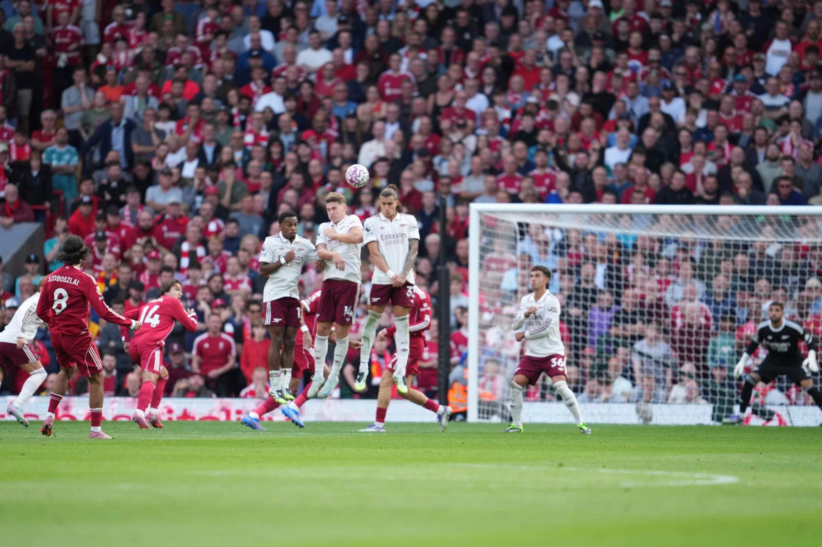 Liverpool's Hungarian midfielder #08 Dominik Szoboszlai (L) strikes the ball over the wall from a free kick to score the opening goal during the English Premier League football match between Liverpool and Arsenal at Anfield in Liverpool, England on August 31, 2025. (AFP)