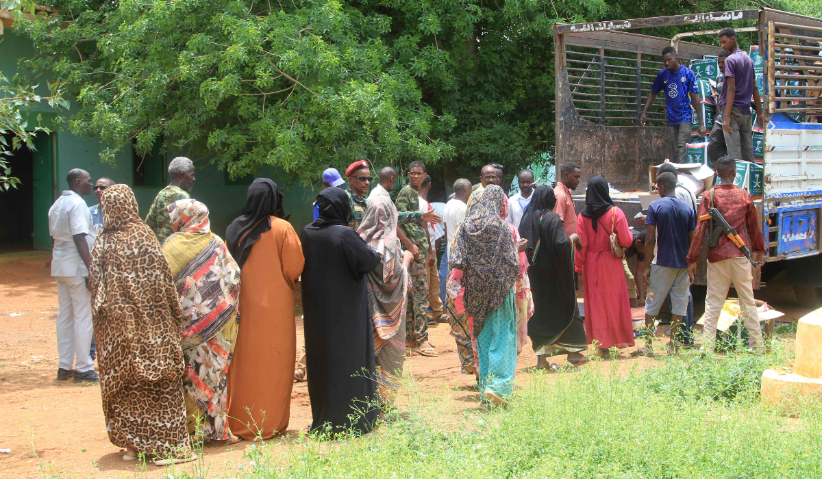 Sudanese, who have recently returned from being displaced, queue to receive humanitarian aid in Ombada, west of Omdurman on August 24, 2025. (AFP)