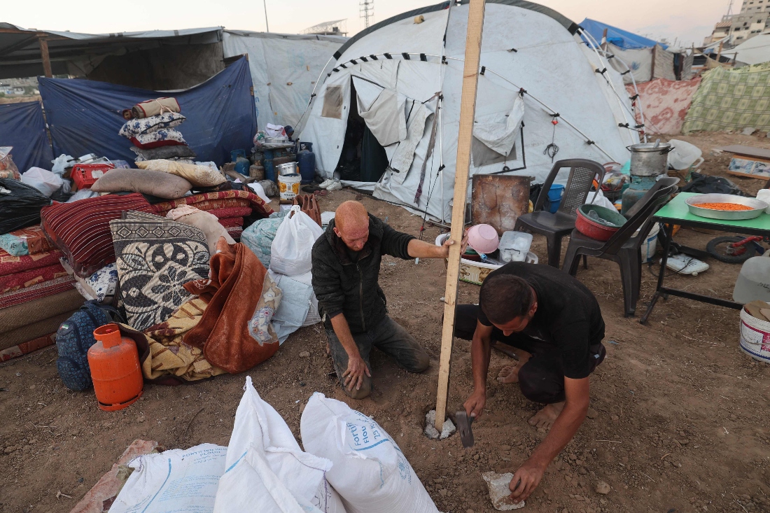 A displaced Palestinian family build a tent at a camp at the Bureij camp for displaced Palestinians in the central Gaza Strip. (AFP)