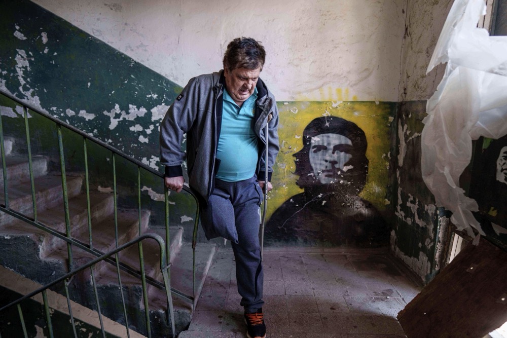 Mykhailo Maistruk, 67, walks downstairs during evacuation from Kostiantynivka, Ukraine, Tuesday. (AP)
