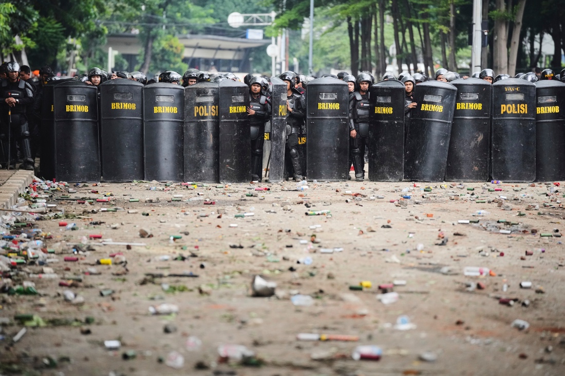 Debris litter the street as police officers take their position following violent protests against lawmakers' allowance and police brutality in Jakarta, Indonesia. (AP)