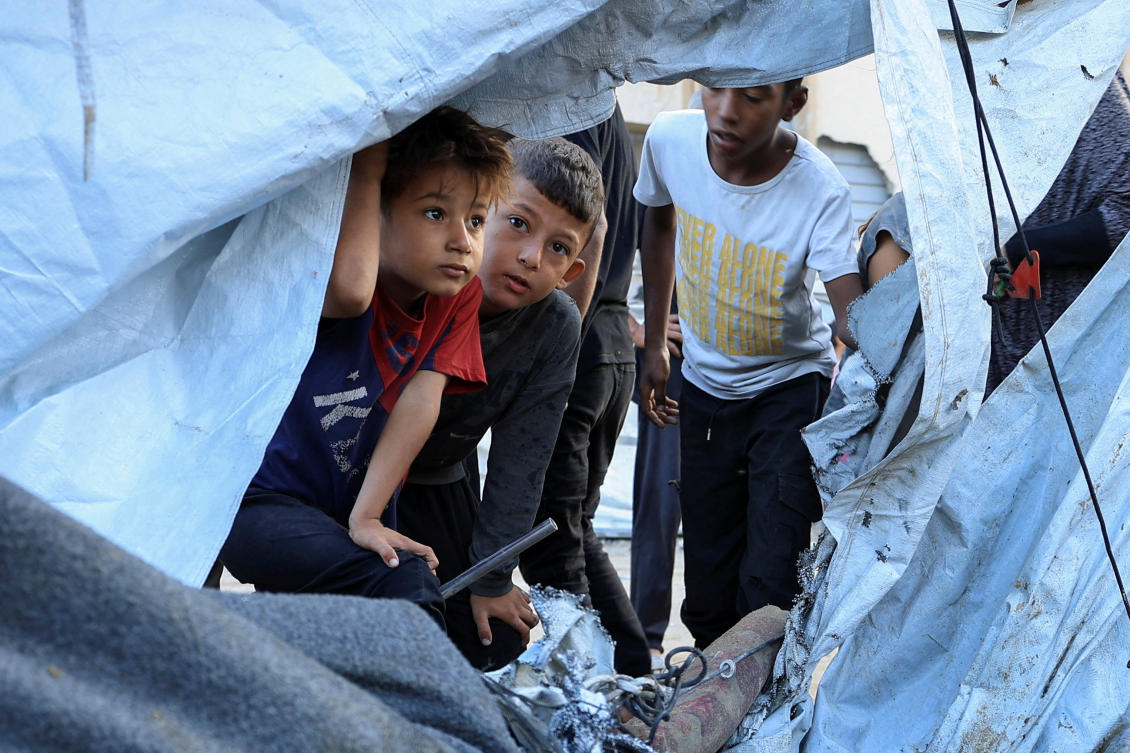 Palestinian children look on at the site of an overnight Israeli strike on a tent, in Gaza City. (REUTERS)