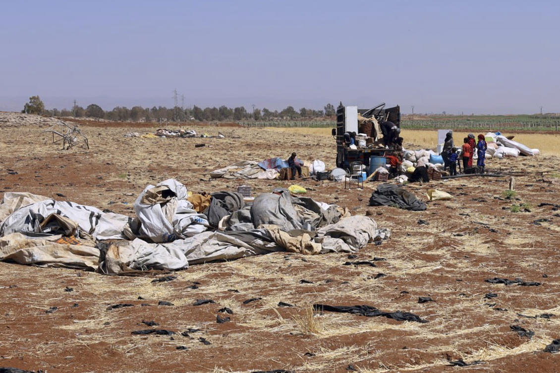 Bedouin people pack their belongings onto a truck, as they flee their villages after Druze militias launched revenge attacks following days of clashes in Sweida city, southern Syria, Thursday, July 17, 2025. (SANA)