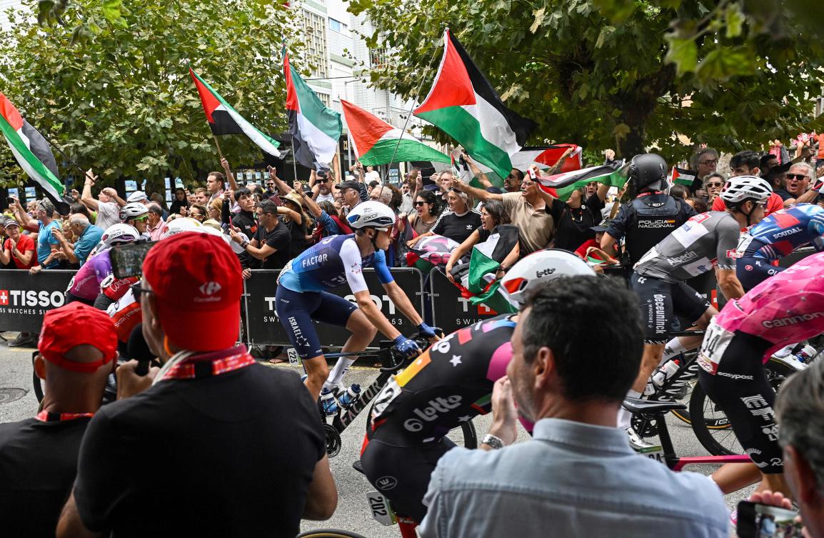 Team Israel Premier-Tech’s Italian rider Marco Frigo (C) rides next to pro-Palestinian demonstrators at the start of the 12th stage of the Vuelta a Espana, a 144,9 km race between Laredo and Corrales de Buelna, on Sept. 4, 2025. (AFP)