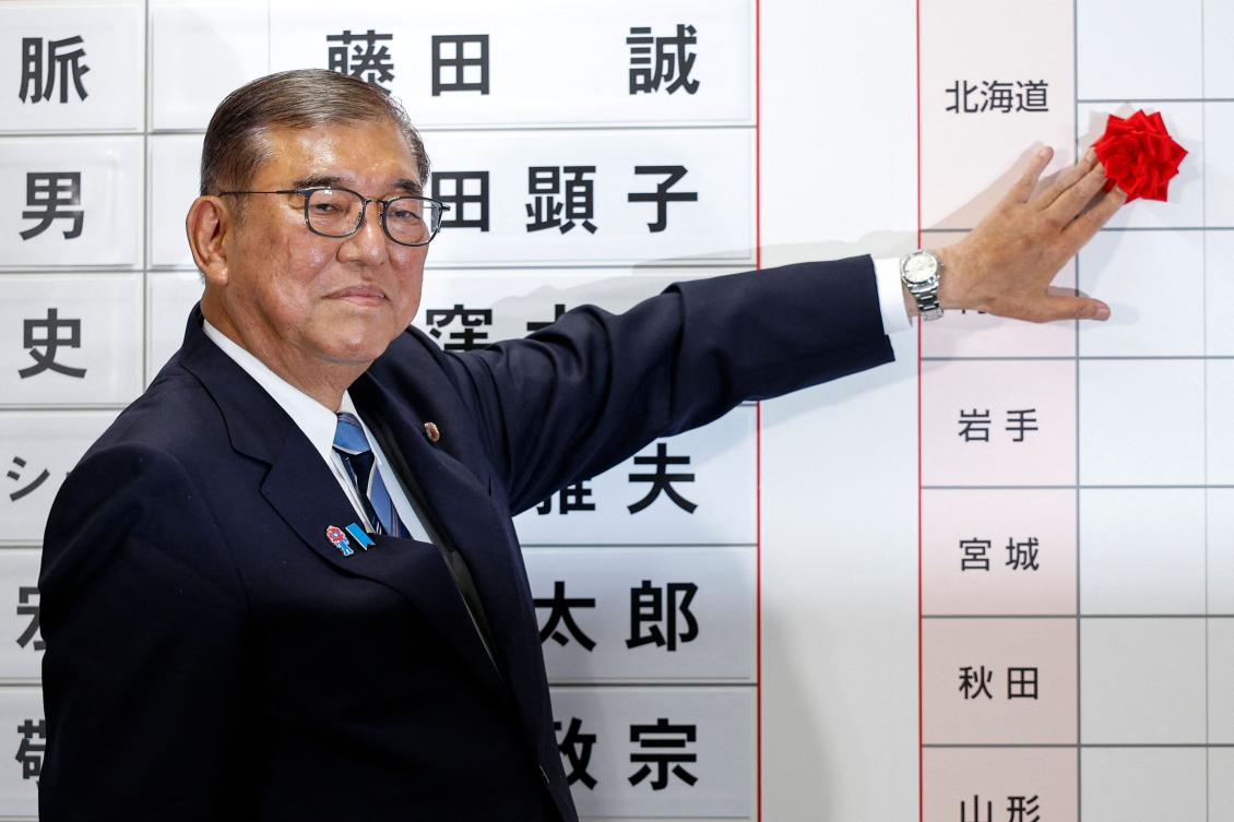 Japan's Prime Minister Shigeru Ishiba places a rose flower. (FILE/AFP)