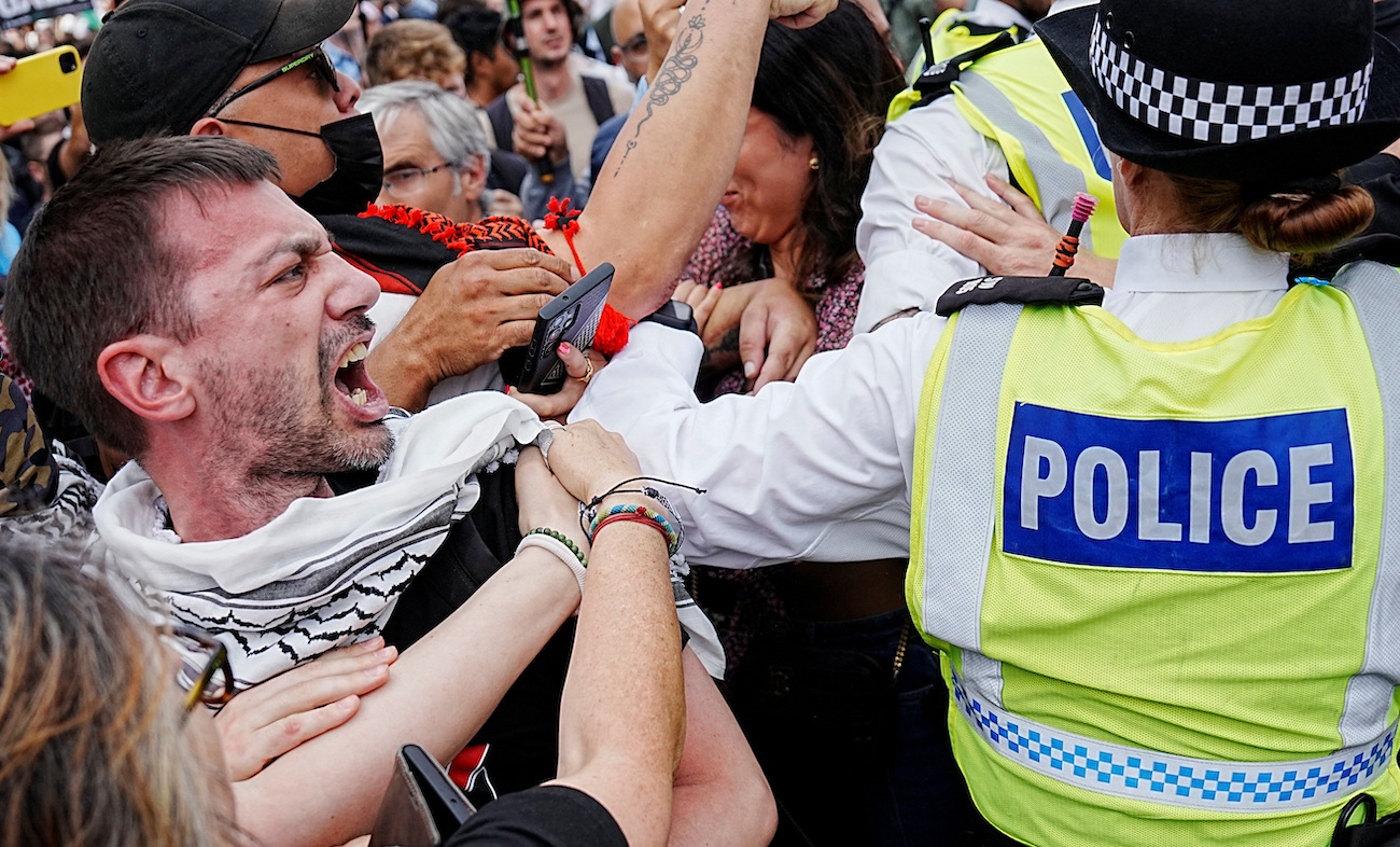 Man reacts as police officers operate during a rally challenging the British government’s proscription of “Palestine Action” under anti-terrorism laws, in Parliament Square, in London, September 6, 2025. (Reuters)