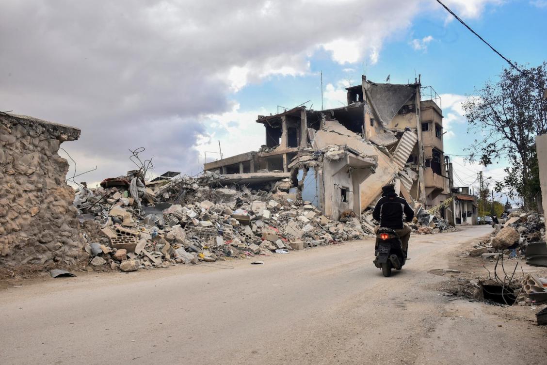 A picture taken a day after a ceasefire between Israel and Hezbollah took hold shows a man ride his moped past destroyed buildings in Baalbek in Lebanon's eastern Bekaa Valley. (File/AFP)