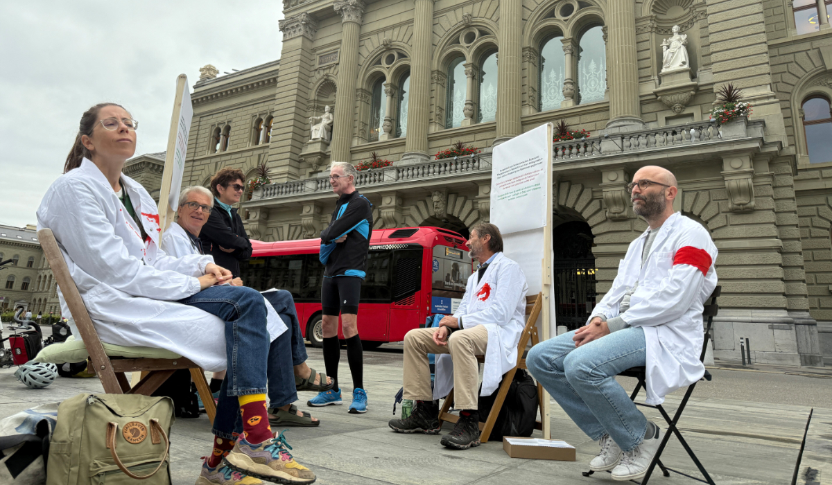 Protesting doctors sit outside the parliament building in Bern on Monday at the start of their hunger strike over the Gaza crisis. (Reuters)