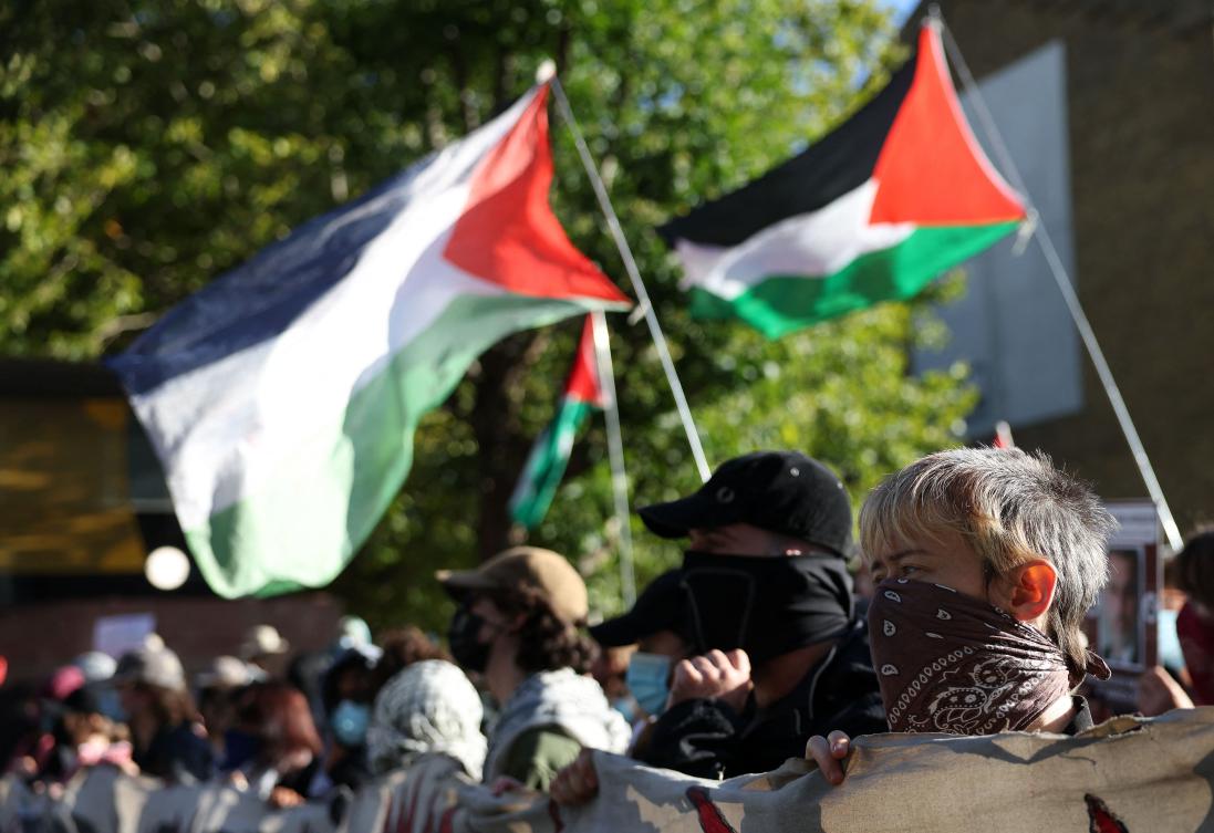Demonstrators wave Palestinian flags as they protest outside the entrance to the Defence and Security Equipment International (DSEI) fair at the ExCeL centre, in east London, on September 9, 2025. (AFP)