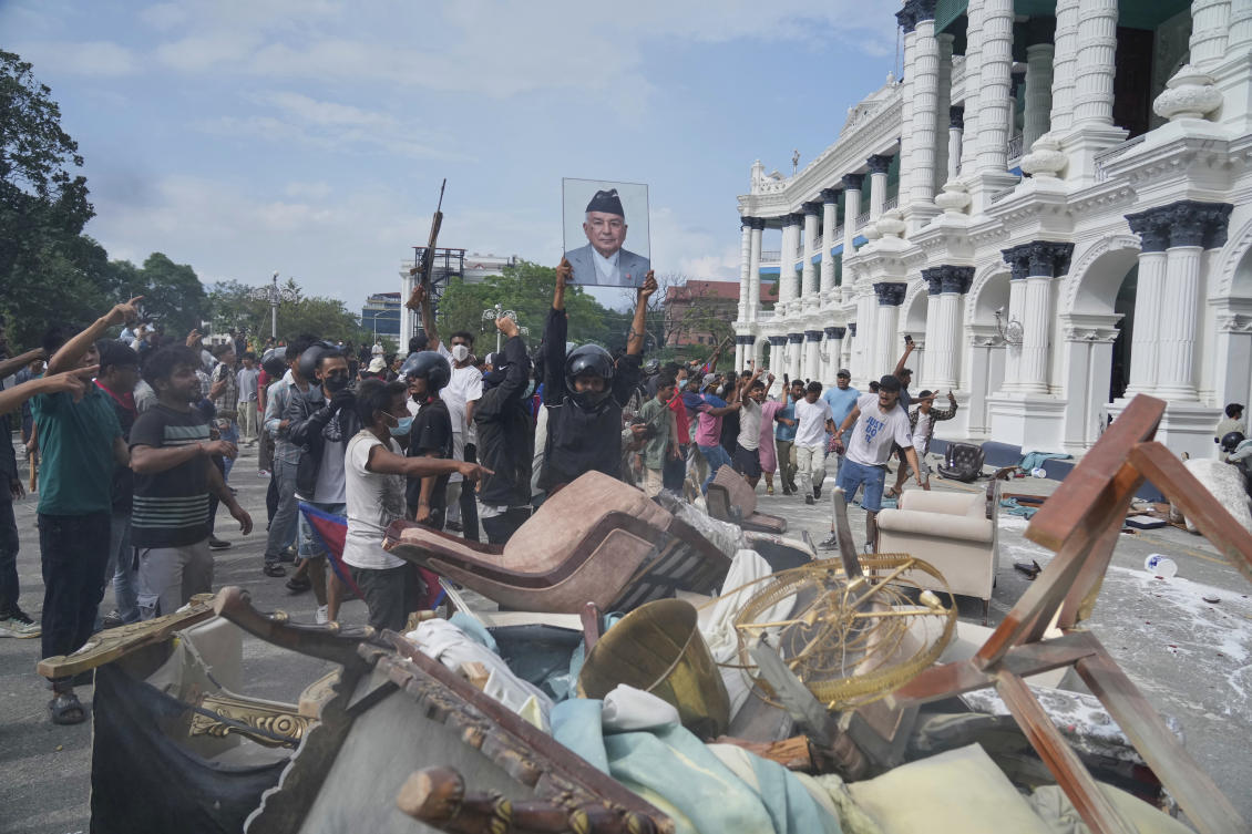 A protester throws a photograph of Nepal Prime Minister Khadga Prasad Oli outside the Singha Durbar, the seat of Nepal's government's various ministries and offices, during a protest against a social media ban and corruption in Kathmandu, Nepal, Tuesday, Sept. 9, 2025. (AP)