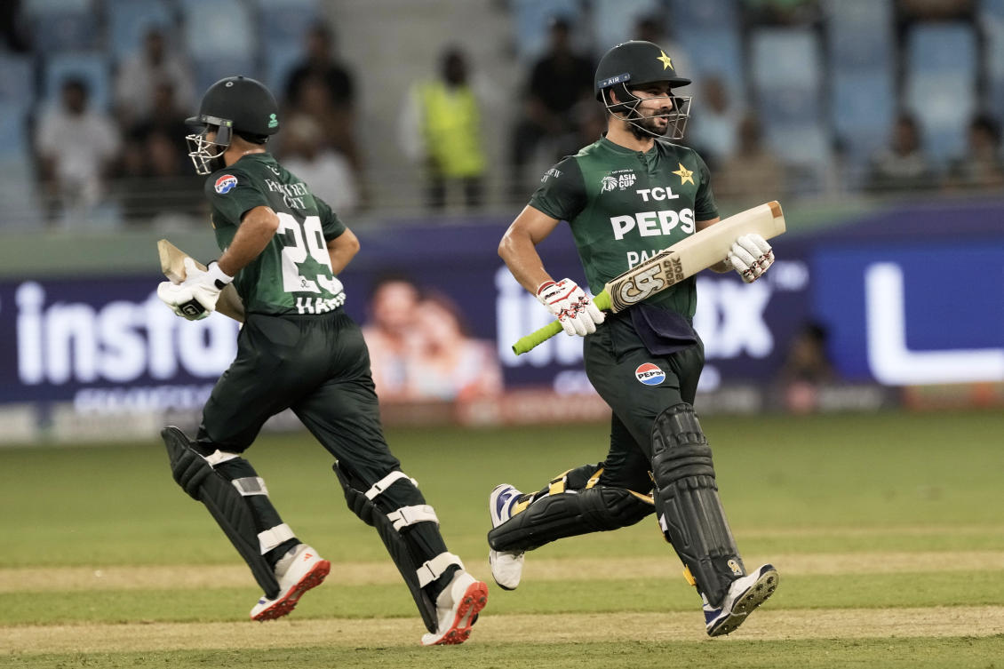 Pakistan’s Sahibzada Farhan, right, and Mohammad Haris run between the wickets to score during the Asia Cup Cricket match between Oman and Pakistan at Dubai International Cricket stadium in Dubai, Sept. 12, 2025. (AP)