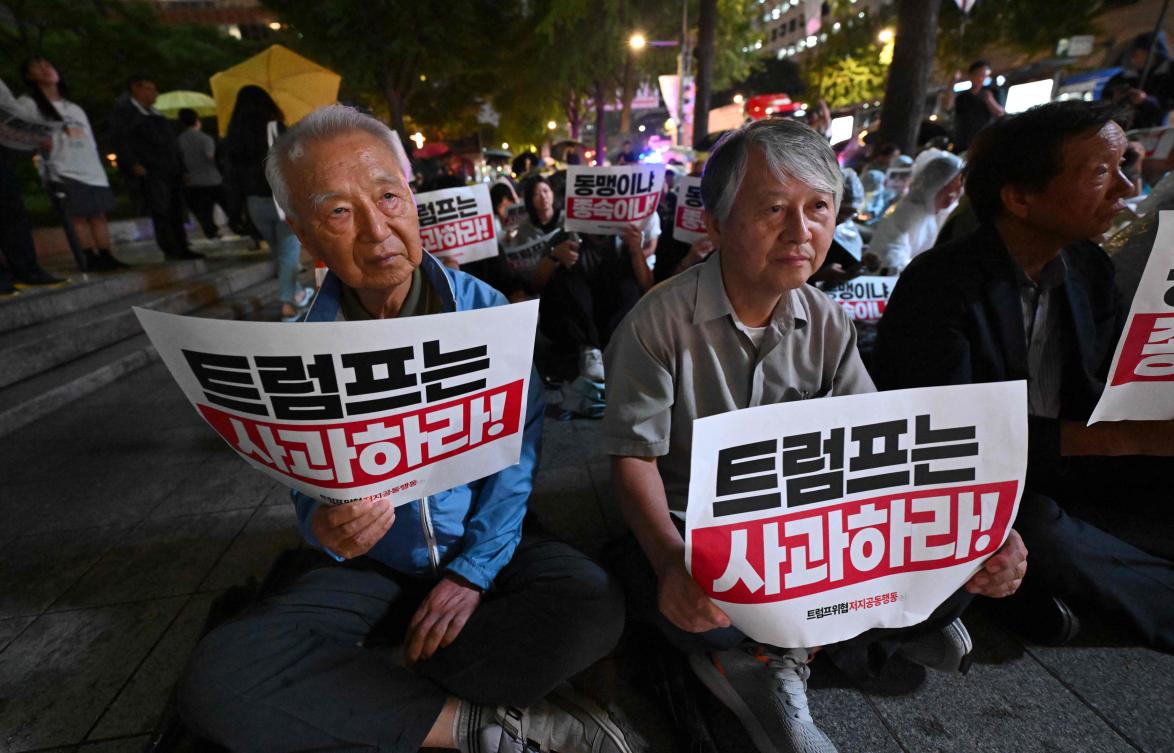 South Korean protesters hold signs reading ‘Trump, apologize!’ during a rally on Sept. 12, 2025 against the detention of South Korean workers after an immigration raid in Georgia. (AFP)