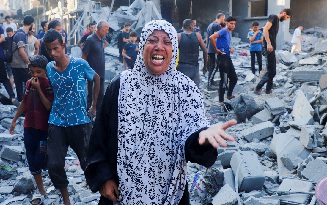 A woman cries as palestinians inspect the site of an overnight Israeli strike on a house in Gaza City. (Reuters)