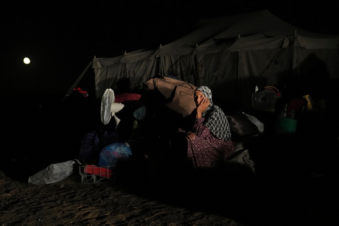 Awatif Abu Jarad, 57, sits beside her family's belongings in Khan Younis, Gaza Strip. (AP)