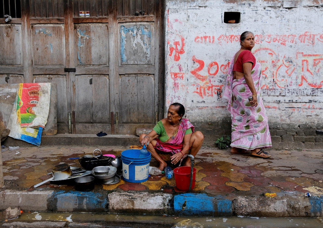 A woman washes utensils on a roadside in Kolkata, India. (Reuters)