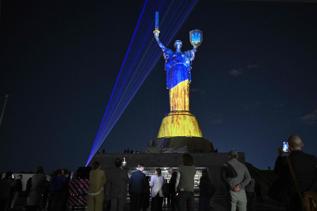Local residents look at the light installation by Ukrainian artist and lighting designer Mykola Kabluka and the Expolight team on the Motherland Monument in Kyiv, Ukraine. (AFP)