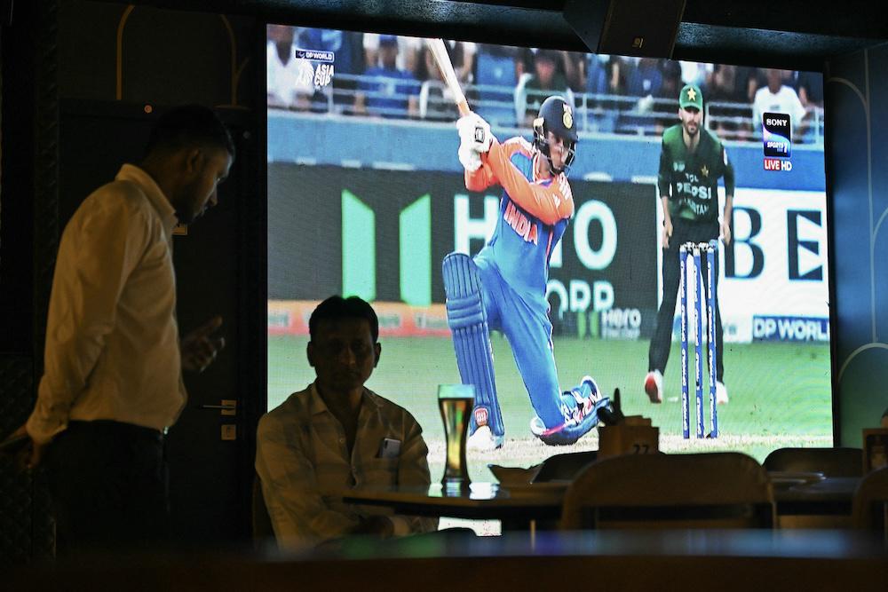 Fans watch a live broadcast of the Asia Cup 2025 Twenty20 International cricket match between Pakistan and India in Bengaluru on Sept. 14, 2025, which overshadowed by a handshake row. (AFP)