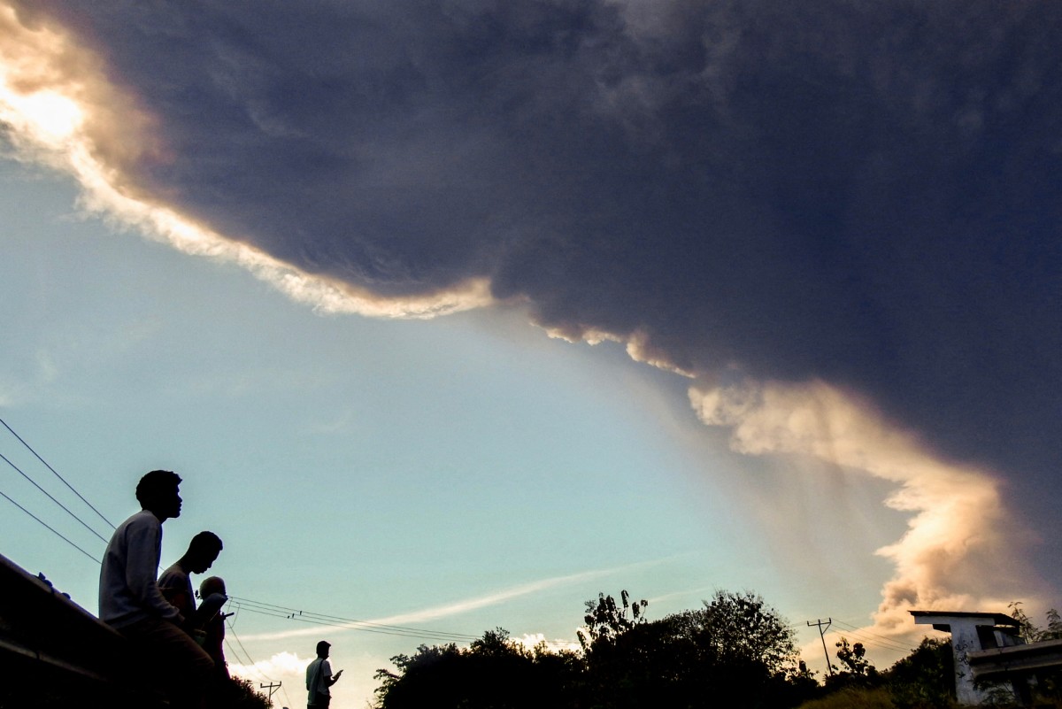 File photo shows villagers as they observe Mount Lewotobi Laki-laki while it erupts, as seen from Nangahale village in Sikka, East Nusa Tenggara on July 7, 2025. (AFP)