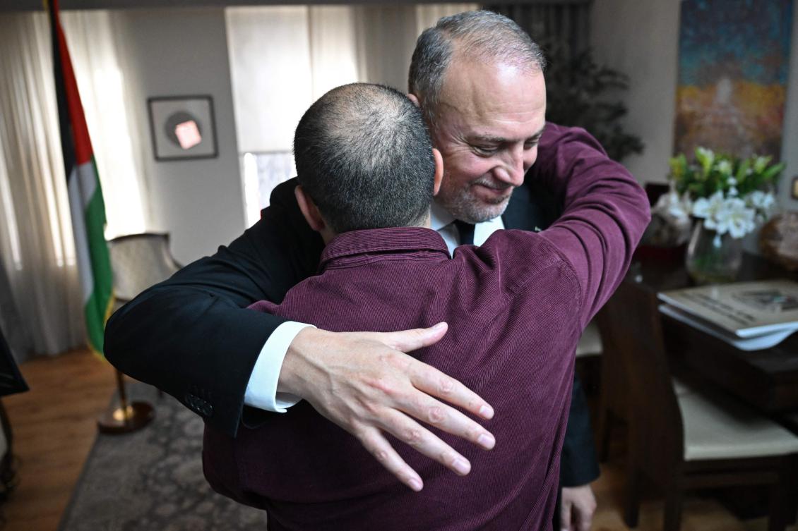 Head of the Palestine Mission to the UK, Husam Zomlot (R) embraces members of staff after watching a television broadcast of Britain’s Prime Minister Keir Starmer formally recognizing The Palestinian State on September 21, 2025 at their Mission in west London. (AFP)