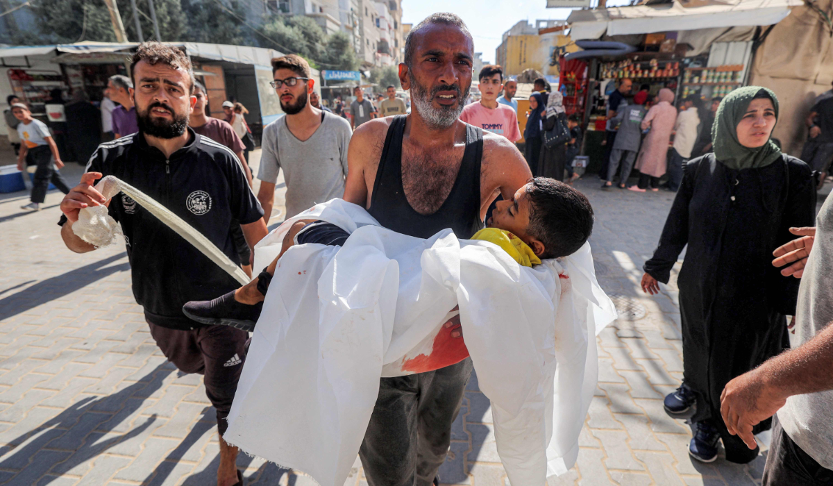 A man reacts as he carries the body of a child killed by reported Israeli bombardment on al-Bureij, outside al-Awda Hospital in Nuseirat in the central Gaza Strip on September 21, 2025. (AFP)