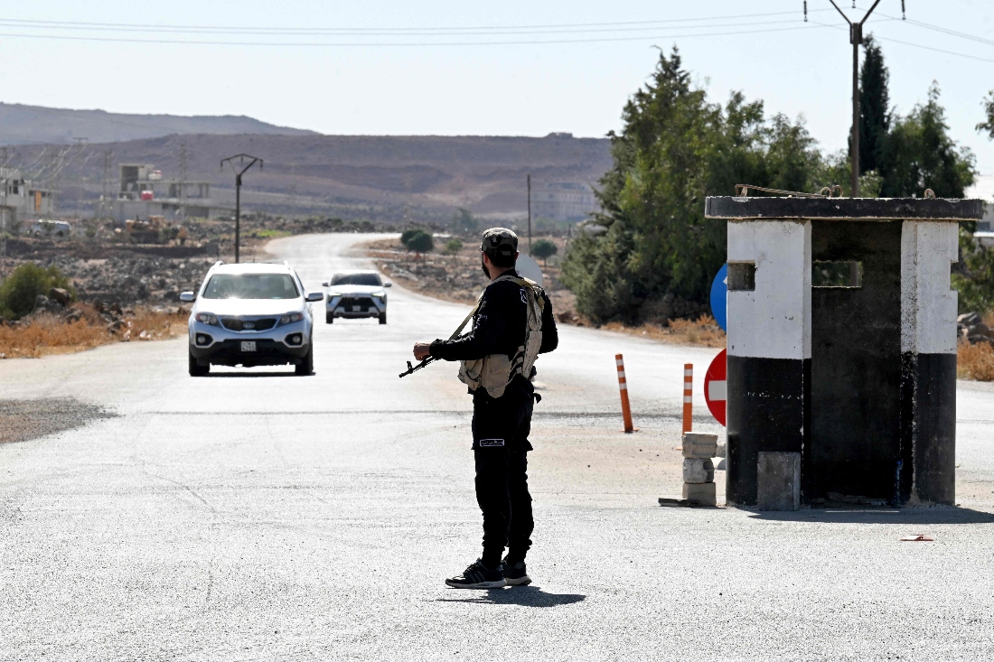 A member of Syria's security forces stands guard at a checkpoint near the city of Quneitra in southern Syria. (AFP)