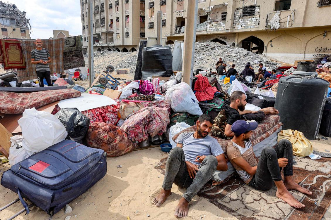 Palestinians displaced by conflict from Gaza City rest by their belongings outside one of the damaged buildings at the Qatari-built Hamad City residential complex in northwestern Khan Yunis, southern Gaza Strip, on September 22, 2025. (AFP)