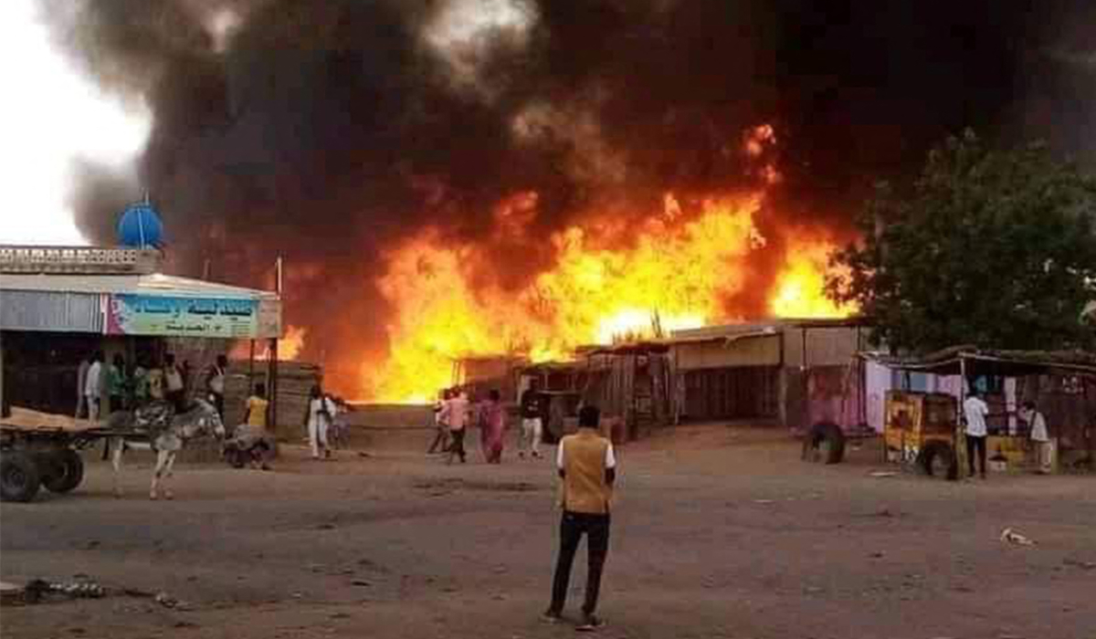 A man stands by as a fire rages in a livestock market area in al-Fasher, the capital of Sudan's North Darfur state, on September 1, 2023, in the aftermath of bombardment by the paramilitary Rapid Support Forces (RSF). (AFP)