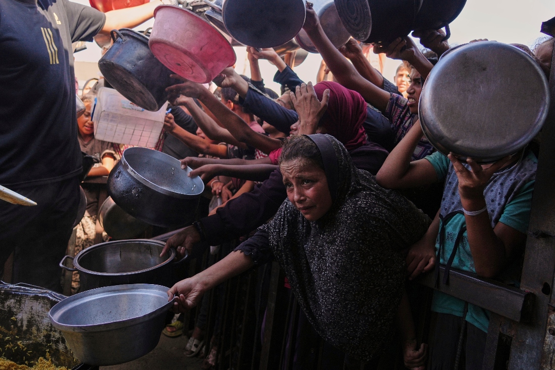 Palestinians struggle to get donated food at a community kitchen in Khan Younis, southern Gaza Strip. (AP)
