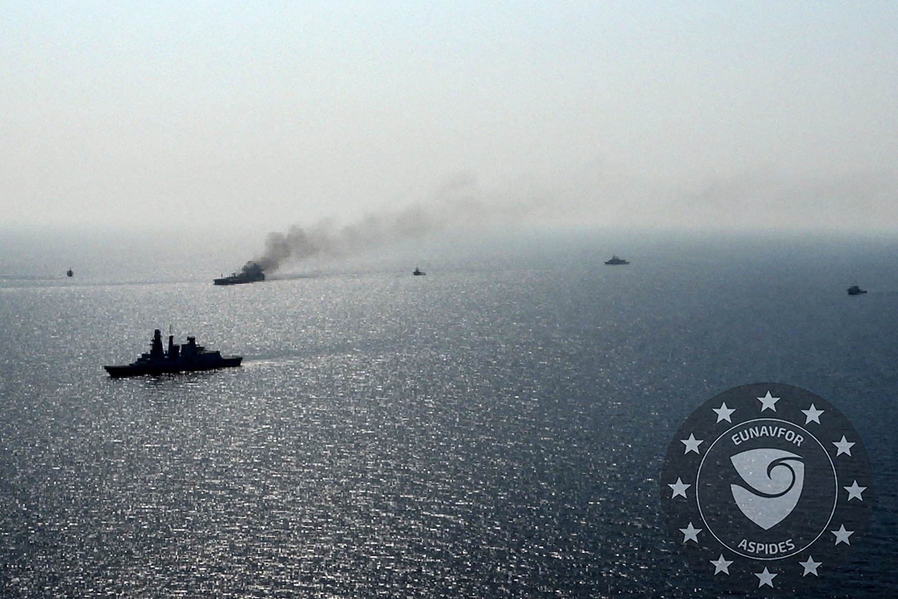 This handout picture provided by EUNAVFOR ASPIDES on September 15, 2024, and dated September 14, shows a vessels surrounding the Greek-owned oil tanker Sounion as smoke billows from it, off the coast of Hodeida in the Red Sea. (AFP)